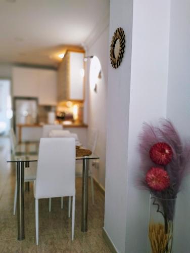 ein Esszimmer mit einem Tisch und einer Vase mit Blumen in der Unterkunft La Cabaña de la Antilla II in La Antilla