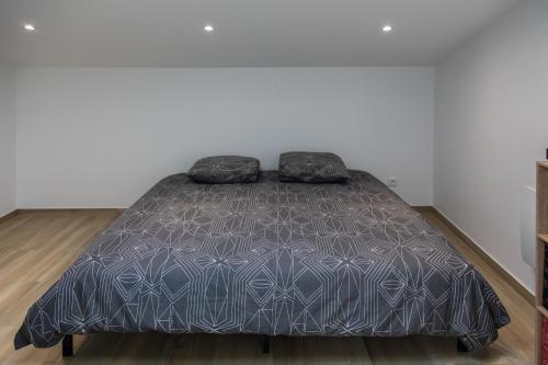 un lit avec deux oreillers dessus dans une chambre dans l'établissement Logement Insolite Ancienne Soue à Cochons Rénovée, à Casteljaloux