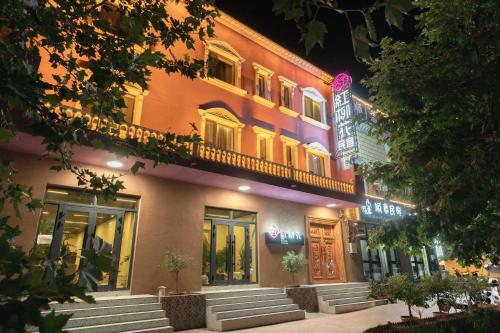a building is lit up at night at 红柳花天台花园民宿Red Willow Flower Hotel in Kashgar