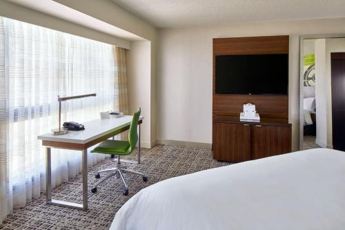 a hotel room with a bed and a desk and a television at Renaissance Nashville Hotel in Nashville