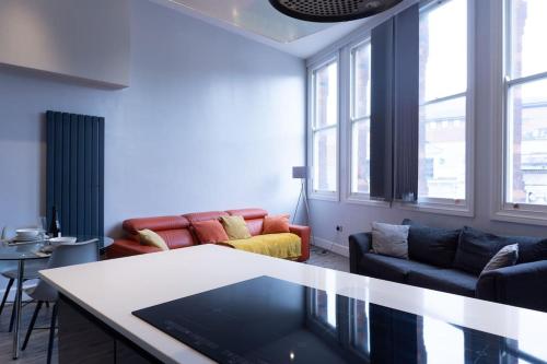 a living room with couches and a table at Spacious Apartment In City Centre - Free Parking in Nottingham
