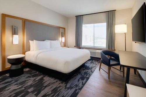 a hotel room with a large white bed and a window at Fairfield by Marriott Inn & Suites Franklin Cool Springs in Franklin