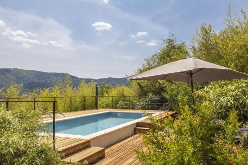 un parasol assis à côté d'une piscine dans l'établissement La Maison des Chataigniers, à Meyrannes