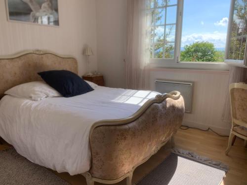 une chambre avec un lit dans une pièce avec deux fenêtres dans l'établissement Maison familiale, à Paulhac