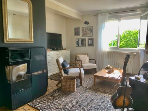 - un salon avec un canapé et une guitare dans l'établissement Maison familiale, à Paulhac