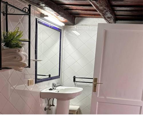 a white bathroom with a sink and a window at Sombrero de Pico C in El Paso