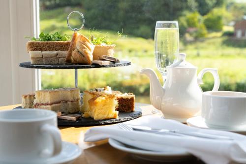 a table with a plate of cakes and tea cups at Skipton Hotel - formerly known as Hotel Rendezvous-Skipton in Skipton