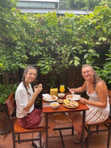 two women sitting at a table eating food at Thuy Xuyen Tam Coc Homestay in Vũ Lâm