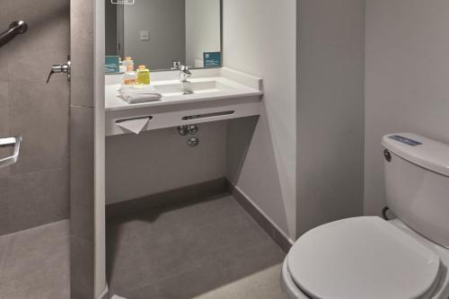 a bathroom with a white toilet and a sink at City Express Junior by Marriott Ciudad de México Sullivan in Mexico City