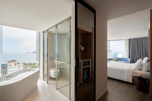 a bathroom with a bath tub and a bedroom at Adamas Boutique Hotel Nha Trang in Nha Trang