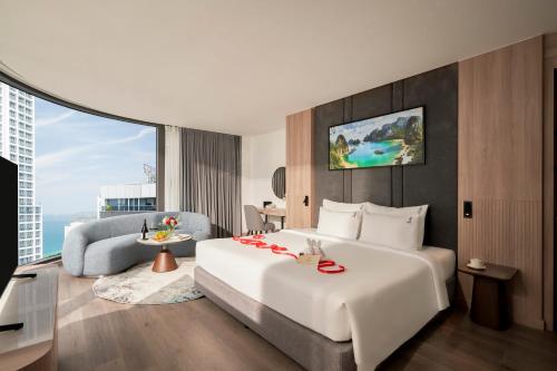 a hotel room with a large bed and a couch at Adamas Boutique Hotel Nha Trang in Nha Trang