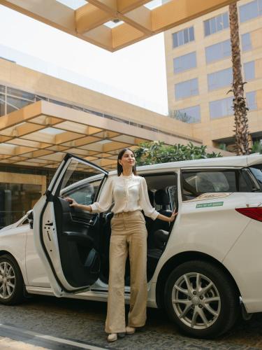 a woman standing in front of a white car at Hyatt Regency Pune Hotel & Residences in Pune