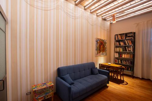 a living room with a blue couch and a table at First Moon-Emme Loft in Milan
