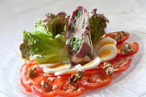 a plate of food with tomatoes and other vegetables at Logis Le Midland in Vichy