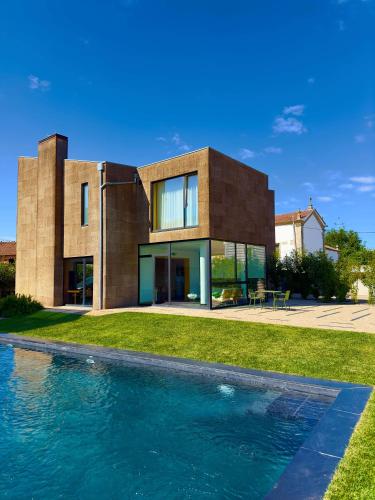 a house with a swimming pool in front of it at PÉ AZUL - Turismo em Espaço Rural - Parque Natural de Montesinho in Bragança