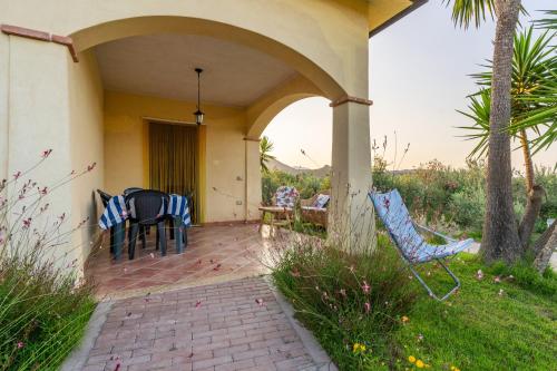 a porch of a house with chairs and a table at Armandiola in Cardedu