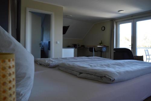 a bedroom with a bed with a white blanket on it at Feriendomizil im Saarschleifenland in Mettlach