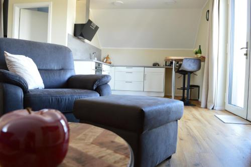 a living room with a couch and a chair and an apple at Feriendomizil im Saarschleifenland in Mettlach