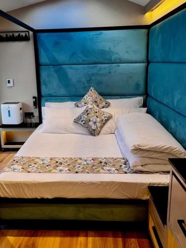 a bed with a blue headboard and pillows on it at Desert Blue Pangong By LexStays in Man