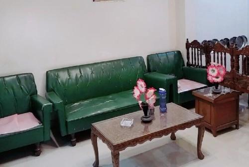 a living room with green couches and a coffee table at Shayok Guest House Ladakh by LexStays in Hundar
