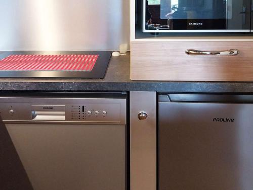 La cuisine est équipée d'un four micro-ondes et d'un lave-vaisselle. dans l'établissement Studio prestige 4 pers, skis aux pieds, cheminée, balcon, sans animaux, wifi libre - FR-1-322-441, aux Orres