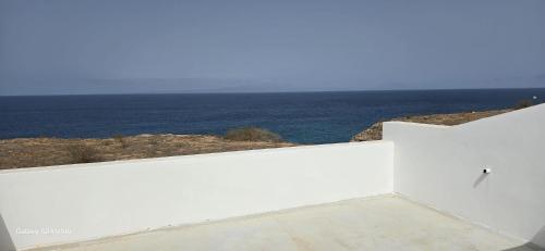 a white wall with the ocean in the background at Serra's Village in Vila do Maio