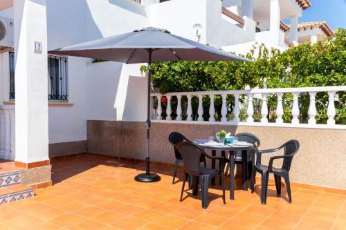 a patio with a table and chairs and an umbrella at Espanatour CINUELICA III in Orihuela Costa