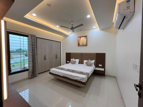 a bedroom with a bed and a large window at Vaidehi Resorts in Ayodhya