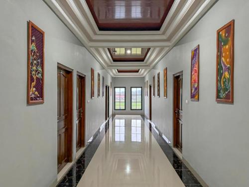 a hallway with white walls and a ceiling with paintings at Hotel Dewata YIA Kulonprogo in Sindutan
