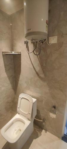 a bathroom with a toilet and a water tank at Sukh Sagar Hotel in Jaipur
