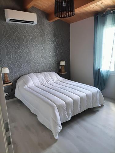 - une chambre avec un grand lit et une couette blanche dans l'établissement Grande maison de vacances récente, à Saint-Denis-dʼOléron