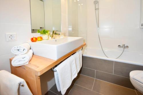 a bathroom with a sink and a tub and a toilet at Schmiedhof in Seefeld in Tirol