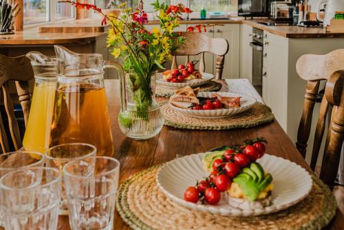 a wooden table with plates of food on it at Old Kyle Farm - Stunning Views - 2 mins from Skye Bridge in Kyleakin