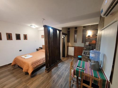 ein Schlafzimmer mit einem Bett und einer Küche darin in der Unterkunft Wasy de Purmamarca in Purmamarca