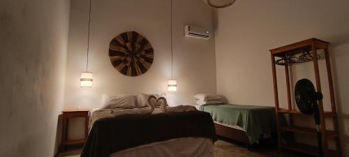 a room with two beds and a mirror and lights at Vila Santa Fé Caraíva in Caraíva