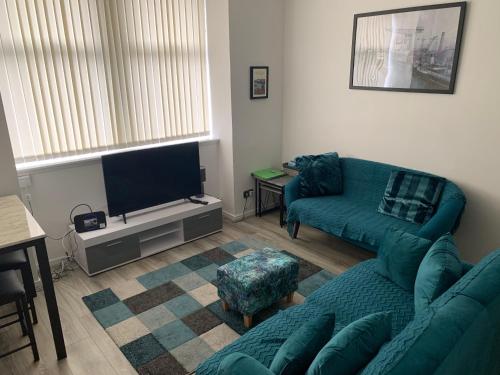 a living room with a couch and a flat screen tv at The Cochno Flat, Clydebank in Dalmuir