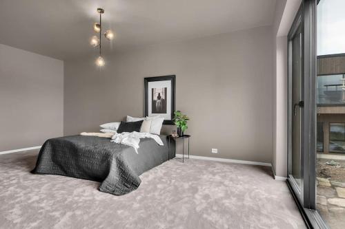 a bedroom with a large bed and a window at Feriested ved Strand & svaberg in Kristiansand