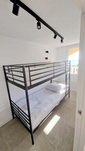 a bedroom with a bunk bed with white sheets at Apartament La Mata in La Mata
