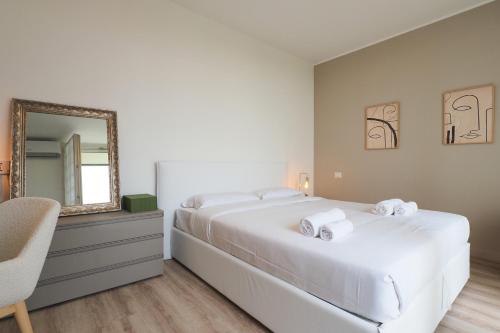 a bedroom with a large white bed and a mirror at Primopiano - Papa Giovanni in Assago