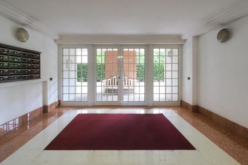 a large living room with a red rug on the floor at Primopiano - Papa Giovanni in Assago