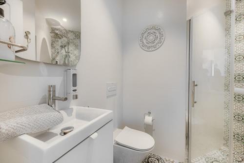 Un baño blanco con inodoro y lavabo. en Secret View Calahonda, en Cabopino