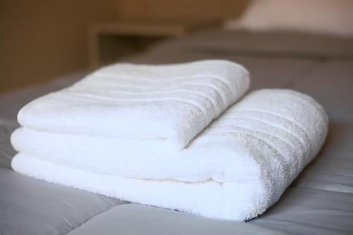 a stack of white towels sitting on a bed at UCO APARTS, tu refugio en el corazón de los Andes in Tupungato