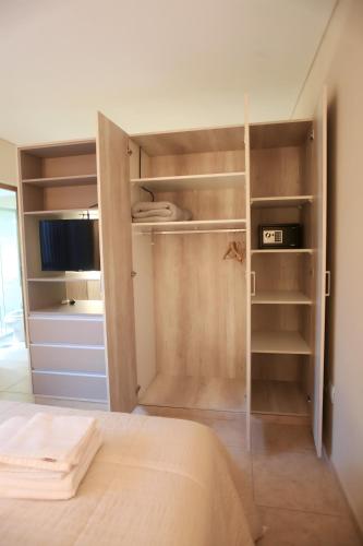 a bedroom with a closet with a bed and a television at UCO APARTS, tu refugio en el corazón de los Andes in Tupungato