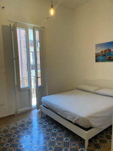 a white bedroom with a bed and a window at Il Canto del Gallo in Crotone
