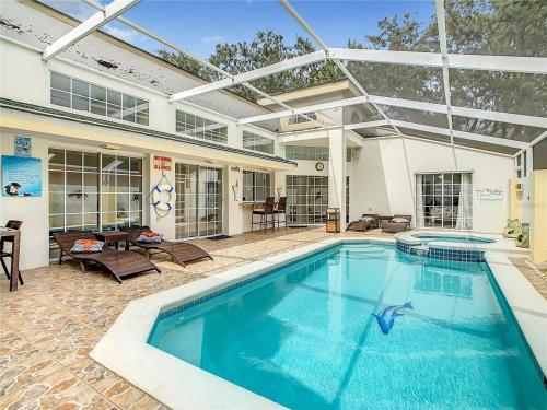 a swimming pool in a house with an overhead patio at Private Pool With Heat - Close to Disney! in Kissimmee