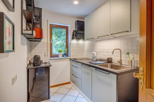 a kitchen with white cabinets and a sink at Viel Platz und Ruhe für 4 am Valentins-Park in Unterschleißheim