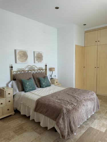 a bedroom with a large bed and a wooden cabinet at Ala Pa cá in Miajadas