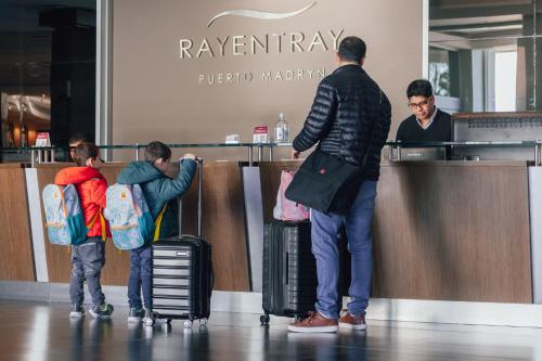 a group of people waiting at a counter with their luggage at Rayentray Grand Hotel in Puerto Madryn