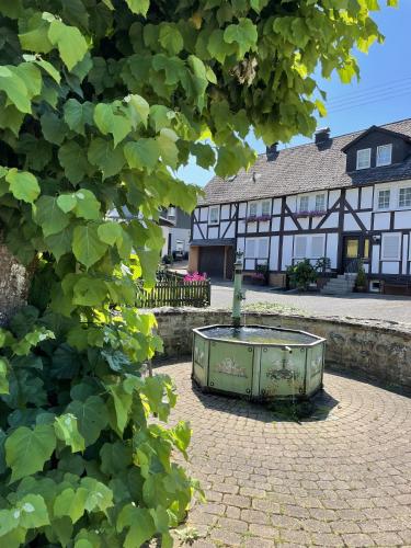 a building with a fountain in the middle of a courtyard at Gittas Paradiesperle in Niederdreisbach