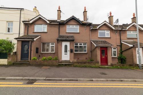 a brown brick house with a red door at Excellent, comfortable location to visit Belfast in Holywood